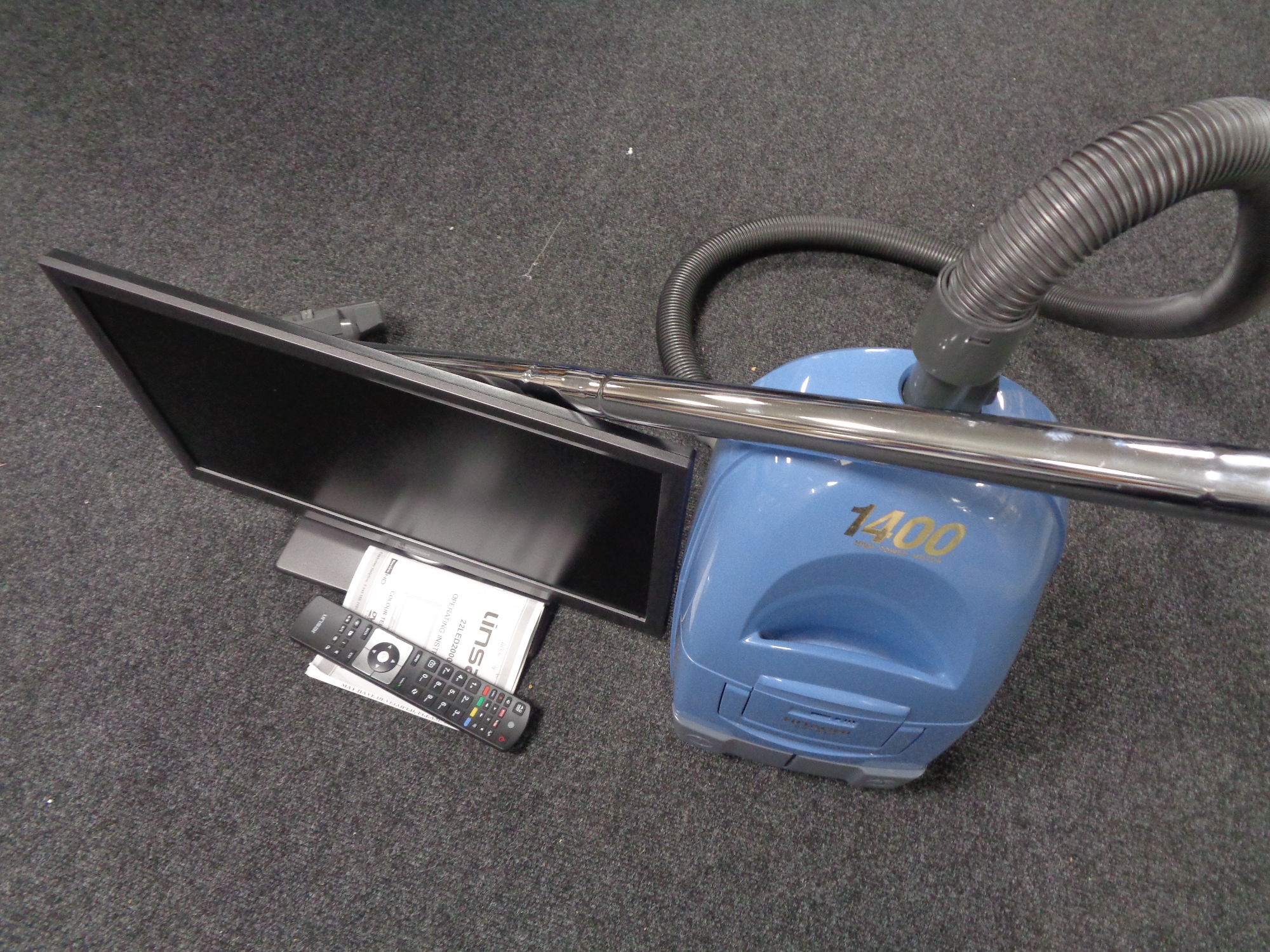A Linsar 22 inch LED TV with remote and a Hitachi cylinder vacuum
