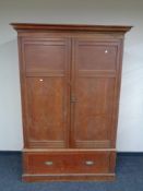An antique pine double door wardrobe fitted drawer beneath