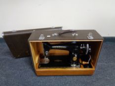 A cased vintage Singer hand sewing machine