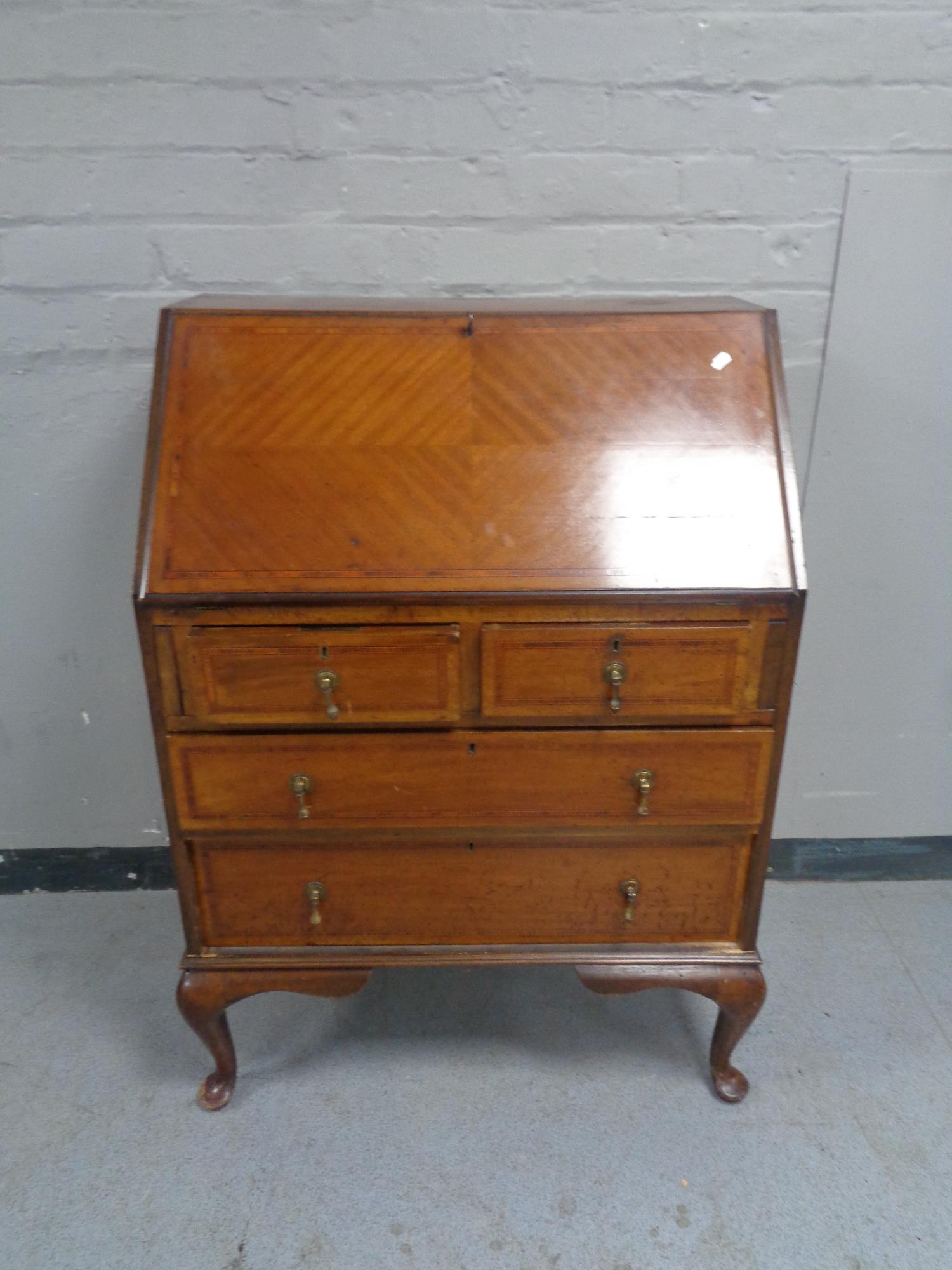 A Victorian inlaid mahogany bureau on Queen Anne legs