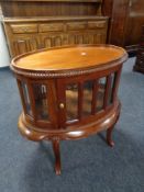 A reproduction oval drinks cabinet on raised legs