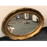 An antique bevel oval gilt framed mirror,