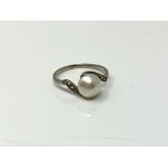 An early twentieth century platinum ring set with a pearl and diamond shoulders, size I.