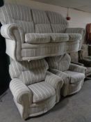 A three piece lounge suite upholstered in a grey striped fabric