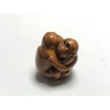 A carved Chinese hardwood netsuke - Two monkeys embracing