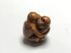 A carved Chinese hardwood netsuke - Two monkeys embracing