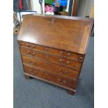 A 19th century oak bureau fitted four drawers beneath with brass drop handles