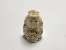 A carved Chinese bone netsuke - Gentleman holding a sack
