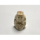 A carved Chinese bone netsuke - Gentleman holding a sack