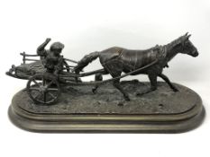 An antique bronze figure of a girl riding on a cart with horse, indistinctly signed Anna **,