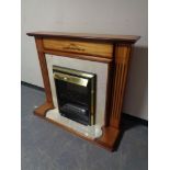 A brass framed coal effect electric fire in surround
