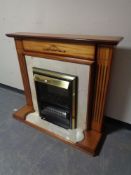A brass framed coal effect electric fire in surround