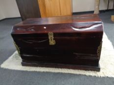 An eastern hardwood dome top trunk with brass mounts and handles,