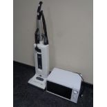 A Sebo automatic upright vacuum together with a microwave