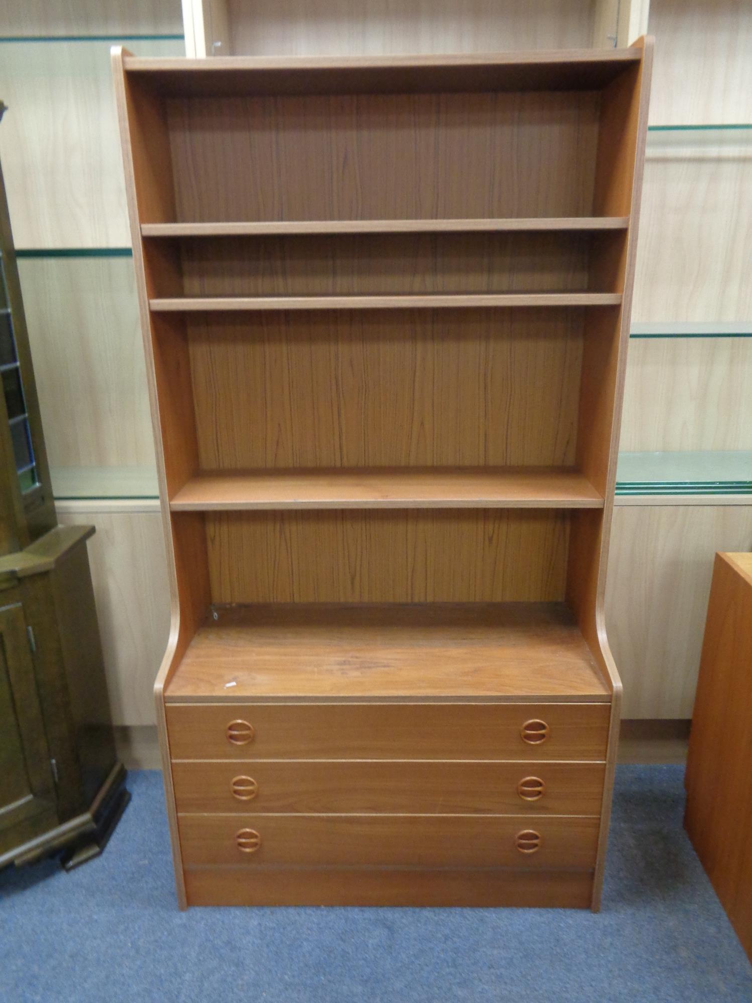 A set of mid 20th century teak effect open bookshelves fitted three drawers beneath