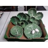 A box containing a quantity of Portuguese leaf dishes and plates,