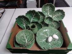 A box containing a quantity of Portuguese leaf dishes and plates,