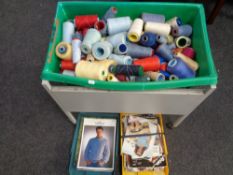 A box on a metal trolley containing a quantity of cotton spools together with two trays containing