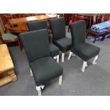 A set of four contemporary dining chairs upholstered in a black fabric
