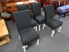 A set of four contemporary dining chairs upholstered in a black fabric