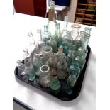 A tray containing assorted antique glass bottles