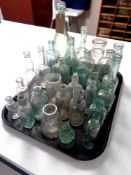 A tray containing assorted antique glass bottles