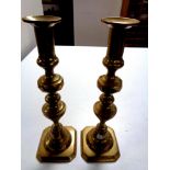 A pair of antique brass candlesticks