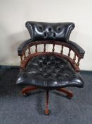 A black button leather swivel captain's desk chair