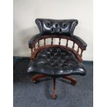 A black button leather swivel captain's desk chair