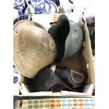 A box containing a 20th century German and British tin helmet together with a French gas mask in