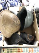 A box containing a 20th century German and British tin helmet together with a French gas mask in