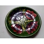 A William Moorcroft Anemone plate on green ground, width 25.