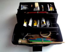 An artist's box containing assorted paints and brushes