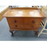 An early 20th century oak two drawer chest on cabriole legs