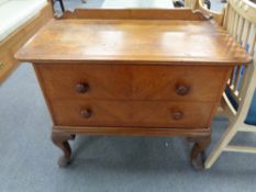 An early 20th century oak two drawer chest on cabriole legs