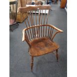 An antique stick back kitchen armchair