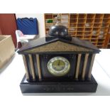 A late 19th century black slate mantel clock with column supports,