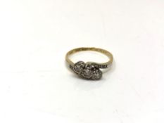 An 18ct gold and platinum three stone diamond crossover ring, size S1/2.