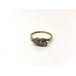 An 18ct gold and platinum three stone diamond crossover ring, size S1/2.