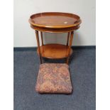 An oval yew wood two tier occasional table together with a tapestry upholstered foot stool on bun