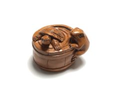 A carved Chinese hardwood netsuke - Turtle and frog by a barrel