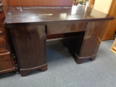 A 20th century twin pedestal desk fitted a drawer