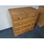 A stripped pine five drawer chest