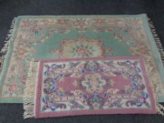 A green floral fringed Chinese rug together with a hearth rug