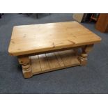 A stripped pine two tier coffee table