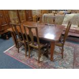 A late 19th century mahogany wind out dining table together with a set of six mahogany chairs