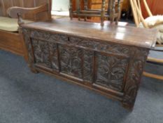 A George III panelled oak coffer with later carving