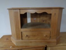 A stripped pine corner television stand fitted a drawer