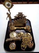 A tray containing assorted brass wares to include ornate desk stand with inkwells, figural clock,