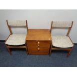 A 20th century teak two drawer bedside chest with slide together with a pair of 20th century teak